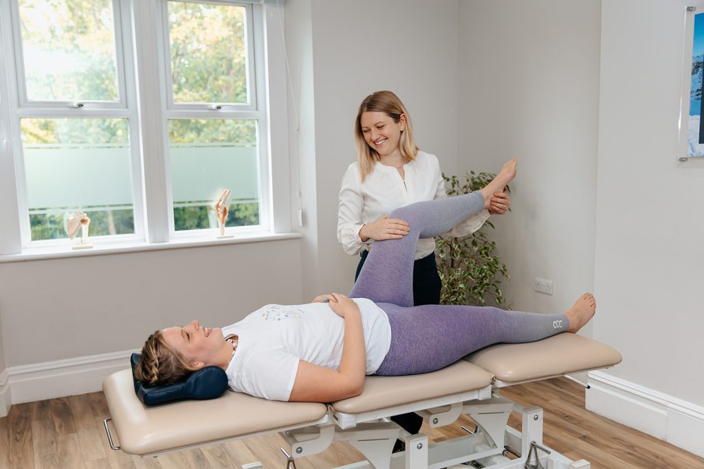 Physiotherapist stretching patients leg